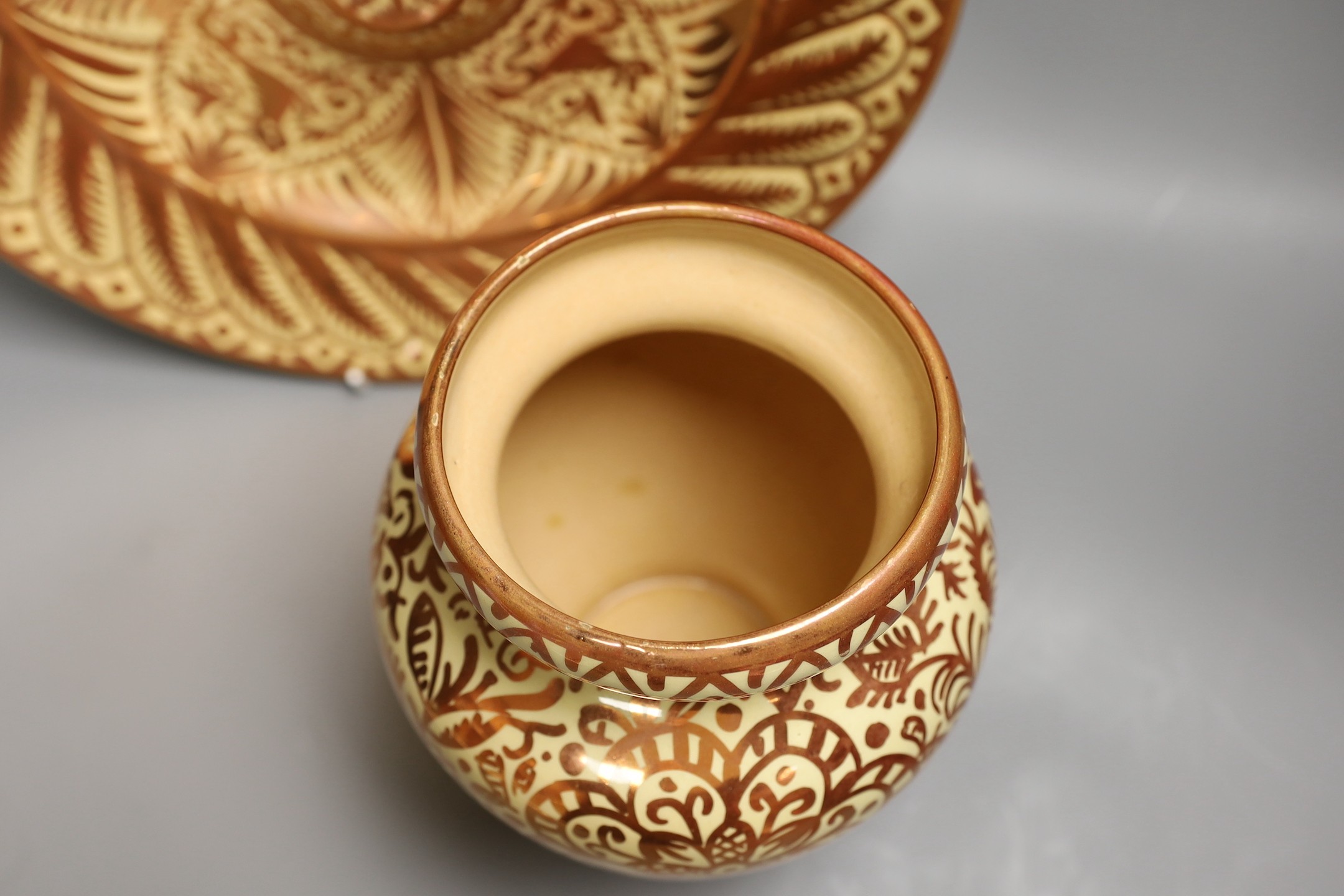 A Hispano Moresque style copper lustre pottery charger and vase, 24cm tall